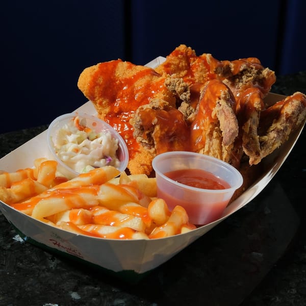 Harold's Chicken KSU fried chicken, fries with hot sauce, coleslaw, and dipping sauce in a paper tray.