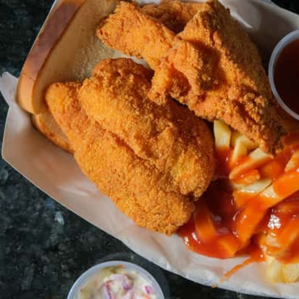 Harolds Chicken KSU fried chicken strips, fries with ketchup, and coleslaw in a paper tray.