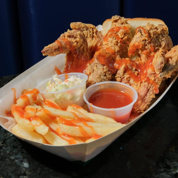 Harold's Chicken KSU fried chicken with hot sauce, fries, coleslaw, and white bread in a paper tray.