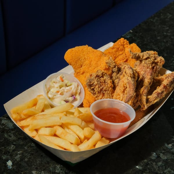 Harold's Chicken KSU fried chicken, fish, fries, coleslaw, and ketchup in a paper tray.